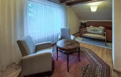 a living room with chairs and a table and a window at 6 Bedroom Amazing Home In Mucharz in Mucharz