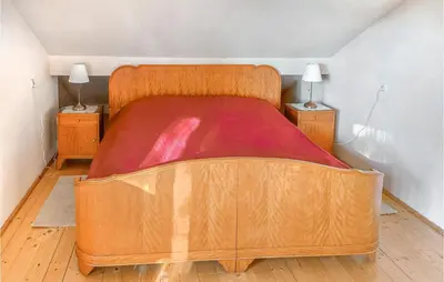 a large wooden bed in a room with two night stands at 6 Bedroom Amazing Home In Mucharz in Mucharz