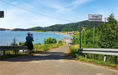 a person standing on a road looking at a beach at 6 Bedroom Amazing Home In Mucharz in Mucharz