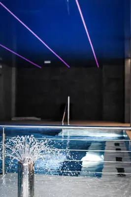 a fountain in a swimming pool with water coming out at Pensjonat Zdrojowy Apartamenty in Rabka