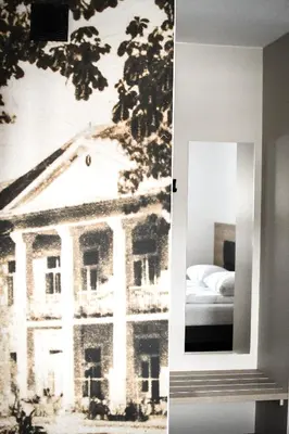 a mirror with a picture of a building on the wall at Pensjonat Zdrojowy Apartamenty in Rabka