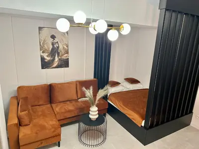 a living room with a couch and a bed at ApartPark Centrum Zator Bronze in Zator