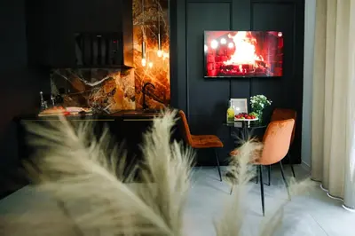 a living room with a table and chairs and a television at ApartPark Centrum Zator Bronze in Zator