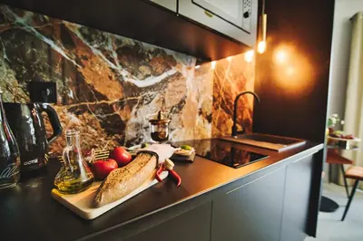 a kitchen counter with fruits and vegetables on a cutting board at ApartPark Centrum Zator Bronze in Zator