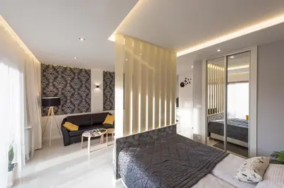 a bedroom with a bed and a living room at White Pearl Apartment in Kraków