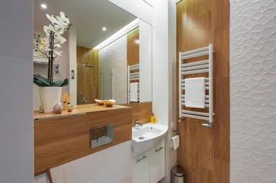 a bathroom with a sink and a mirror at White Pearl Apartment in Kraków