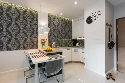 a kitchen with white cabinets and a table with fruit on it at White Pearl Apartment in Kraków