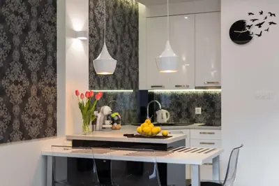 a kitchen with white cabinets and a table with fruit on it at White Pearl Apartment in Kraków