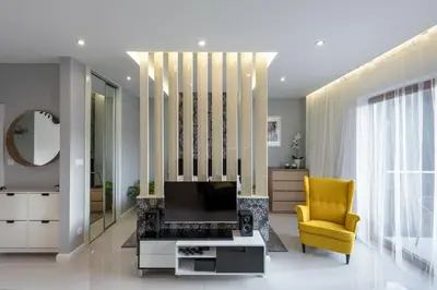 a living room with a yellow chair and a television at White Pearl Apartment in Kraków
