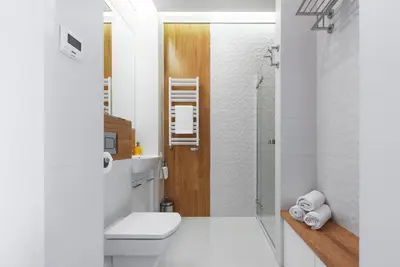 a white bathroom with a toilet and a shower at White Pearl Apartment in Kraków