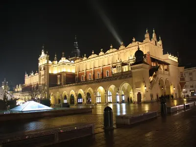 a large building is lit up at night at atHome in Kraków
