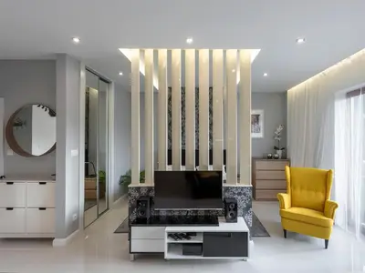 a living room with a tv and a yellow chair at Black Pearl Apartment in Kraków