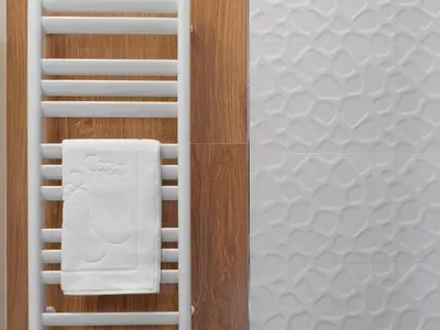 a white towel on a towel rack next to a bed at Black Pearl Apartment in Kraków