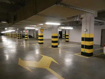 an empty parking garage with two arrows on the floor at Black Pearl Apartment in Kraków