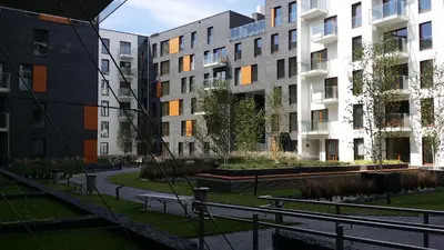 a park with benches and buildings in a city at Black Pearl Apartment in Kraków