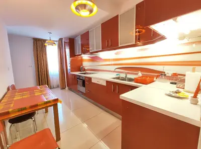 a kitchen with brown cabinets and a table in it at Kazimierza Wielkiego 84 by Homeprime in Kraków