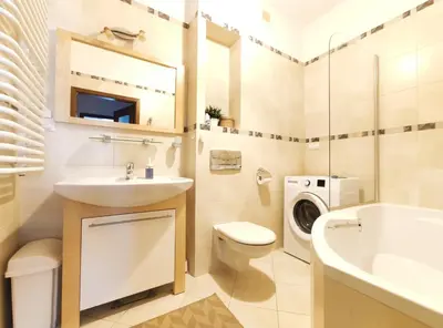 a bathroom with a sink toilet and a washing machine at Kazimierza Wielkiego 84 by Homeprime in Kraków