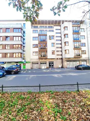 a building with cars parked in front of a street at Kazimierza Wielkiego 84 by Homeprime in Kraków