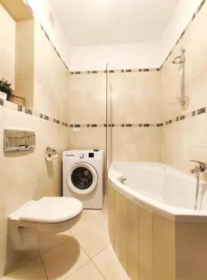 a bathroom with a toilet and a washing machine at Kazimierza Wielkiego 84 by Homeprime in Kraków