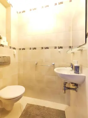 a bathroom with a toilet and a sink at Kazimierza Wielkiego 84 by Homeprime in Kraków