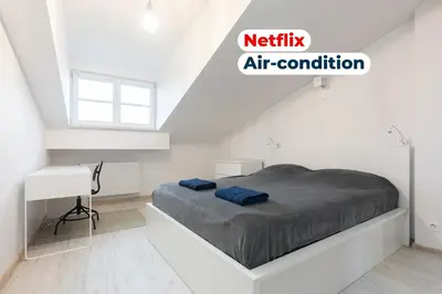 a white room with a bed and a desk at Apartment Kazimierz near Wawel Castle in Kraków