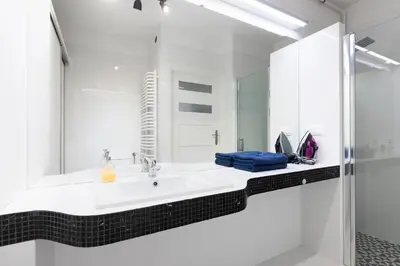a white bathroom with a sink and a mirror at Apartment Kazimierz near Wawel Castle in Kraków