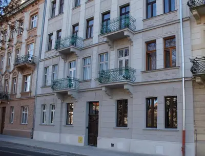 a large white building with balconies on a street at Apartment Kazimierz near Wawel Castle in Kraków