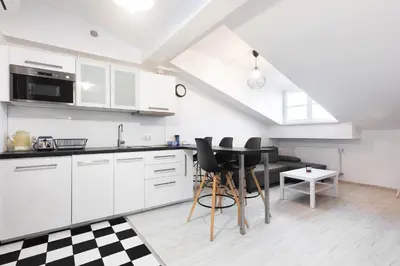 a kitchen with white cabinets and a table at Apartment Kazimierz near Wawel Castle in Kraków
