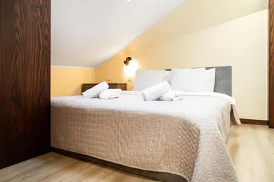 a bedroom with a large bed with white sheets at Househost Apartment:Bracka 3/15A in Kraków
