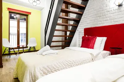 two beds in a room with a brick wall at Househost Apartment:Bracka 3/15A in Kraków