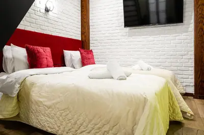 a bedroom with two beds with red and white pillows at Househost Apartment:Bracka 3/15A in Kraków