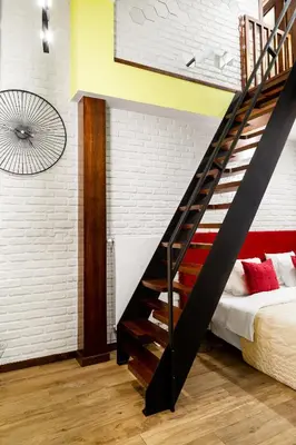 a bedroom with a staircase next to a bed at Househost Apartment:Bracka 3/15A in Kraków