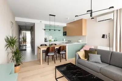 a living room and kitchen with a couch and a table at Premium Designer Apartment - Quiet and Central in Kraków