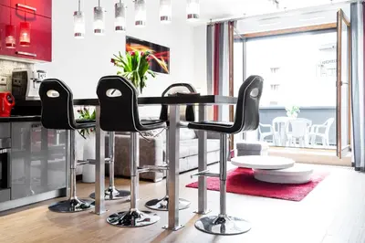 a kitchen with a table and black chairs at HOUSEHOST Apartment:Lubicz 17D/5 in Kraków