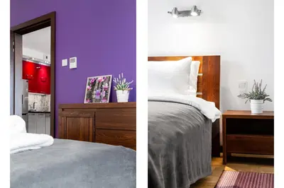 a bedroom with purple walls and a bed and a mirror at HOUSEHOST Apartment:Lubicz 17D/5 in Kraków