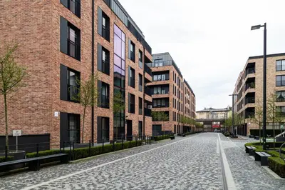 an empty street in front of a brick building at HOUSEHOST Apartment:Lubicz 17D/5 in Kraków
