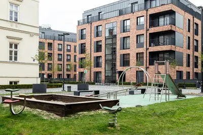 a park with a playground in front of a building at HOUSEHOST Apartment:Lubicz 17D/5 in Kraków