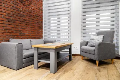 a table and two chairs and a brick wall at HOUSEHOST Apartment:Bracka 3/15B in Kraków