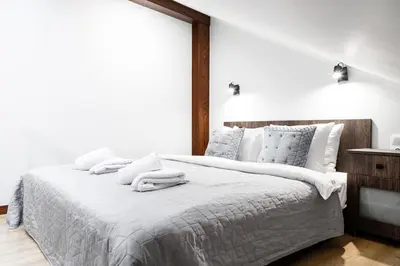 a white bedroom with a large bed with towels on it at HOUSEHOST Apartment:Bracka 3/15B in Kraków