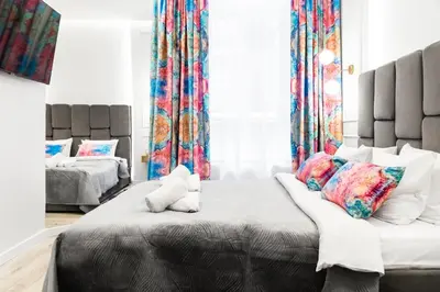 a bedroom with a large bed with a teddy bear on it at HOUSEHOST Apartment: Św.Gertrudy 10/0.2 in Kraków