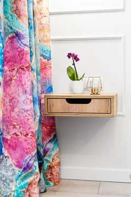 a table with a plant on it next to a colorful curtain at HOUSEHOST Apartment: Św.Gertrudy 10/0.2 in Kraków
