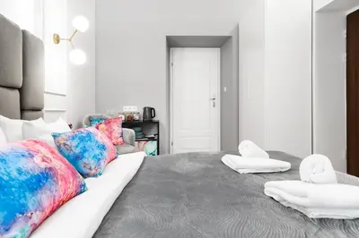 a bedroom with a large bed with colorful pillows at HOUSEHOST Apartment: Św.Gertrudy 10/0.2 in Kraków