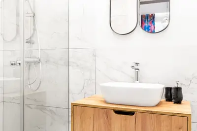 a white bathroom with a sink and a shower at HOUSEHOST Apartment: Św.Gertrudy 10/0.2 in Kraków