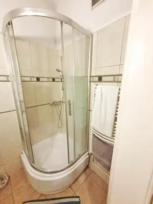a shower with a glass door in a bathroom at Main Square Rooms in Kraków