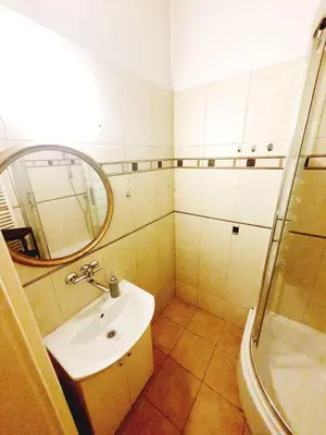 a bathroom with a sink and a mirror and a shower at Main Square Rooms in Kraków