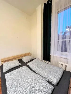 a bedroom with two beds in front of a window at Main Square Rooms in Kraków