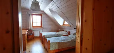 a room with three beds in a room with a attic at Sarni Szlak in Zawoja
