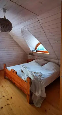 a bedroom with a wooden bed with a window at Sarni Szlak in Zawoja