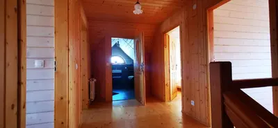 a hallway in a log cabin with a door open at Sarni Szlak in Zawoja