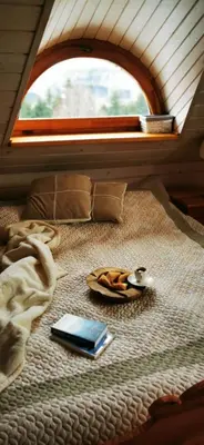 a bed with a plate of food and a cell phone at Sarni Szlak in Zawoja